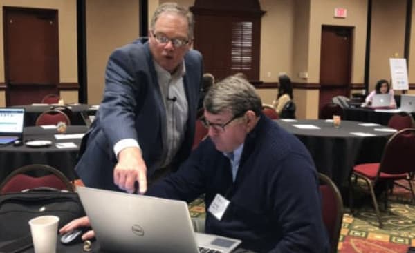 Two People Looking at a Laptop